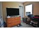 Bedroom with dresser, TV, and a window that brings in natural light at 410 5Th S St, Dundee, FL 33838