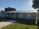 Charming single-story home featuring a metal roof and a well-maintained front yard and a covered porch at 410 5Th S St, Dundee, FL 33838