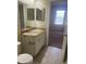 Bathroom vanity featuring a sink, white cabinets, granite countertops and decorative mirrors at 417 Southern Pecan Cir # 201, Winter Garden, FL 34787
