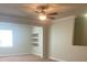 Comfortable living room space with a ceiling fan, window, and built-in shelves for decor at 417 Southern Pecan Cir # 201, Winter Garden, FL 34787