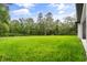 Expansive lush green backyard with surrounding mature trees provides privacy at 4528 Yorkshire Ln, Kissimmee, FL 34758