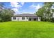 The backyard showcases a spacious lawn and the home's modern exterior with a covered patio at 4528 Yorkshire Ln, Kissimmee, FL 34758