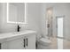 Modern bathroom features a vanity with black hardware, a lighted mirror, and a glass walk-in shower at 4528 Yorkshire Ln, Kissimmee, FL 34758
