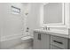 Modern bathroom with a shower-tub combination, sleek gray cabinets, and an illuminated mirror at 4528 Yorkshire Ln, Kissimmee, FL 34758