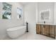 Bright bathroom with a soaking tub, wood grain vanity, and an illuminated mirror at 4528 Yorkshire Ln, Kissimmee, FL 34758