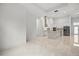 Open-concept living space showcasing the modern kitchen with stainless appliances and white tile flooring at 4528 Yorkshire Ln, Kissimmee, FL 34758