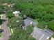 Aerial view of a home nestled among mature trees, featuring a screened-in pool and well-manicured lawns at 460 W Palm Valley Dr, Oviedo, FL 32765