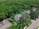 Aerial shot of a property with a screened-in pool surrounded by lush, mature trees and well-kept lawns at 460 W Palm Valley Dr, Oviedo, FL 32765