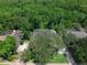 Aerial view of a home with mature landscaping and a screened-in pool, surrounded by lush greenery at 460 W Palm Valley Dr, Oviedo, FL 32765