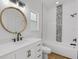 Bright bathroom features a modern vanity, round mirror, and tub with shower featuring decorative tiling at 460 W Palm Valley Dr, Oviedo, FL 32765
