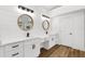 Bright bathroom with double vanity, white cabinets, and round mirrors at 460 W Palm Valley Dr, Oviedo, FL 32765