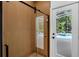 Modern bathroom features a wood-look tiled wall shower with sliding glass door, next to a door leading to the screened-in pool area at 460 W Palm Valley Dr, Oviedo, FL 32765