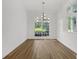 Bright dining room featuring wood floors, a modern chandelier, and a large window overlooking the yard at 460 W Palm Valley Dr, Oviedo, FL 32765