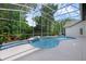 Beautiful kidney-shaped pool surrounded by lush greenery and covered by a screen enclosure at 460 W Palm Valley Dr, Oviedo, FL 32765