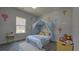 A cute bedroom decorated with hot air balloon wall decor features a gray wood-look floor and a canopy bed at 5110 Sw 158Th St, Ocala, FL 34473