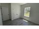 Bright bedroom with a gray wood-look floor, a closet with bifold doors, and a bright window at 5110 Sw 158Th St, Ocala, FL 34473