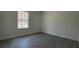 This bedroom has gray wood-look floors, white trim, and a single window with natural light at 5110 Sw 158Th St, Ocala, FL 34473