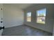 This bedroom features sleek, gray wood-look floors and two windows allowing for ample natural light at 5110 Sw 158Th St, Ocala, FL 34473