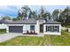 A beautiful single Gathering home with manicured lawn, a paved driveway, and a modern white and gray exterior at 5110 Sw 158Th St, Ocala, FL 34473