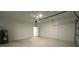 Empty garage with painted walls and concrete floor; door open to backyard at 5110 Sw 158Th St, Ocala, FL 34473