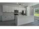 Bright kitchen featuring white cabinets, stainless steel appliances, quartz countertops, and modern pendant lighting at 5110 Sw 158Th St, Ocala, FL 34473