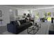 Modern living room with stylish furniture, an open kitchen, and a dining area with natural light at 5110 Sw 158Th St, Ocala, FL 34473