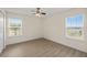 Bright bedroom with wood-look floors, two windows with blinds, and natural light at 5447 Vineland Rd # 1308, Orlando, FL 32811