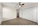 Neutral bedroom features wood-look floors, ceiling fan, and a closet for storage at 5447 Vineland Rd # 1308, Orlando, FL 32811