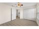 Well-lit bedroom features light wood flooring, ceiling fan, and a double-door closet for ample storage at 5447 Vineland Rd # 1308, Orlando, FL 32811