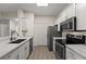 Modern kitchen with stainless steel appliances, white countertops, and ample cabinet space at 5447 Vineland Rd # 1308, Orlando, FL 32811