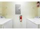 Functional laundry area with washer, dryer, overhead storage, and a mounted fire extinguisher at 5447 Vineland Rd # 1308, Orlando, FL 32811