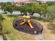 Outdoor playground with slides, benches, and a secure fence in a grassy area at 5447 Vineland Rd # 1308, Orlando, FL 32811