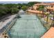 Community tennis court with green surface, surrounded by a fence and green landscape at 5447 Vineland Rd # 1308, Orlando, FL 32811