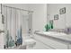 Bright bathroom with a cactus-themed shower curtain and a white vanity with granite countertop at 5857 Beefmaster Rd, St Cloud, FL 34771