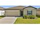 Charming single-story home featuring a well-maintained lawn and a two-car garage at 5857 Beefmaster Rd, St Cloud, FL 34771