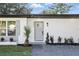 Inviting front entrance of a home featuring well-maintained landscaping and a modern gray door at 606 Faber Dr, Orlando, FL 32822