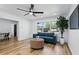Bright living room with modern decor, sleek ceiling fan, hardwood floors, and view into dining area at 606 Faber Dr, Orlando, FL 32822