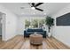 Bright living room with modern decor, sleek ceiling fan, hardwood floors, and large windows at 606 Faber Dr, Orlando, FL 32822