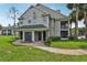 Inviting townhouse exterior with a garage, charming entryway, and lush green lawn at 6088 Westgate Dr # 201, Orlando, FL 32835