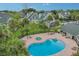 An aerial view of a kidney-shaped pool and hot tub surrounded by a brick patio and palm trees at 6088 Westgate Dr # 201, Orlando, FL 32835