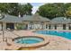 A close up of the pool with a hot tub, various chairs, and a clubhouse in the background at 6088 Westgate Dr # 201, Orlando, FL 32835