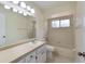 Bathroom featuring shower-tub combo, white vanity, mirror, toilet, and tiled floors at 622 N Goodrich Dr, Deltona, FL 32725