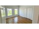 Bright bedroom with hardwood floors, two windows, and white closet at 6741 Heavitree Dr, Sebring, FL 33876