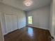 Bright bedroom with wood floors, a window, and a closet with paneled doors at 6741 Heavitree Dr, Sebring, FL 33876