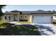 Charming single-Gathering home with well-maintained lawn, gray roof, and attached two-car garage at 6741 Heavitree Dr, Sebring, FL 33876