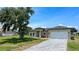 Charming home showcasing a well-kept lawn, brick driveway, and two-car garage at 6741 Heavitree Dr, Sebring, FL 33876
