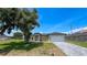 Front yard featuring a well-manicured lawn and a brick driveway leading to a two-car garage at 6741 Heavitree Dr, Sebring, FL 33876