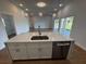 Kitchen island with stainless steel appliances and view into the adjacent dining area and living room at 6741 Heavitree Dr, Sebring, FL 33876