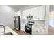 Kitchen with stainless steel refrigerator, oven, microwave, white cabinets and quartz countertops at 6741 Heavitree Dr, Sebring, FL 33876