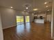 Spacious living room with wood-look floors, modern lighting and a view into the kitchen at 6741 Heavitree Dr, Sebring, FL 33876